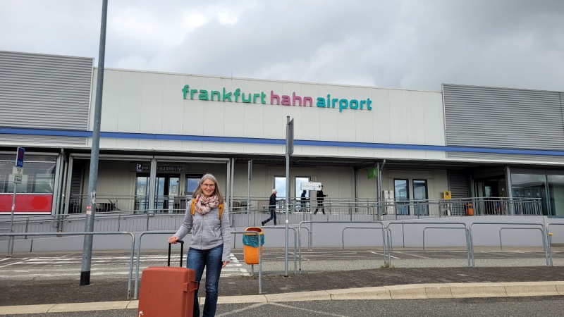 Frau mit Koffer vor dem Flughafen Frankfurt Hahn im Hunrück
